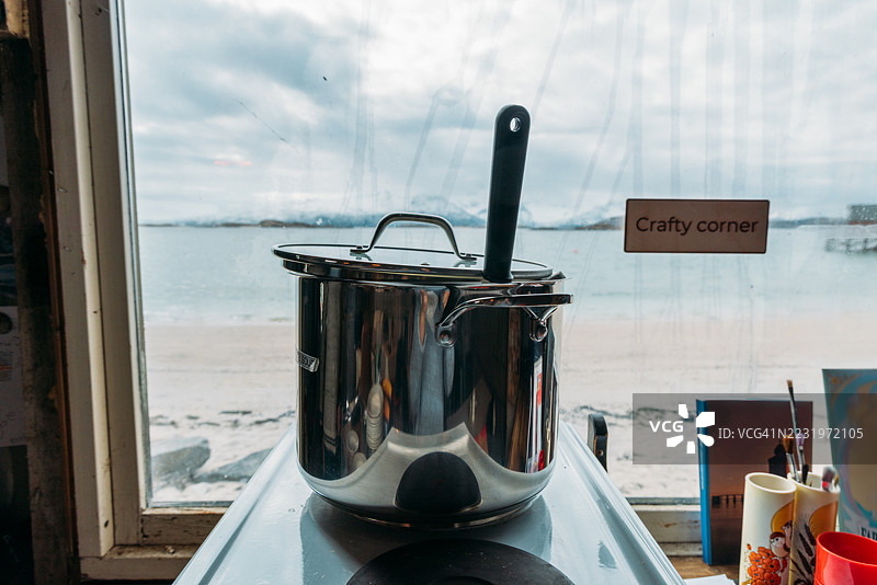 海边窗户旁的不锈钢锅在炉子上图片素材
