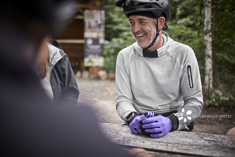 快乐的山地车手在森林里与朋友们休息图片素材