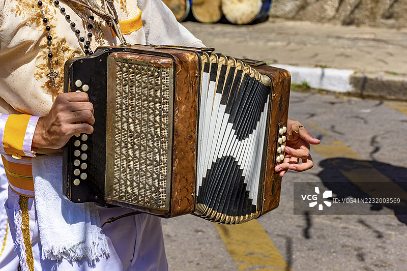 在巴西米纳斯吉拉斯州贝洛哈里藏特的孔加多节上，手风琴演奏者与他的乐器。图片素材