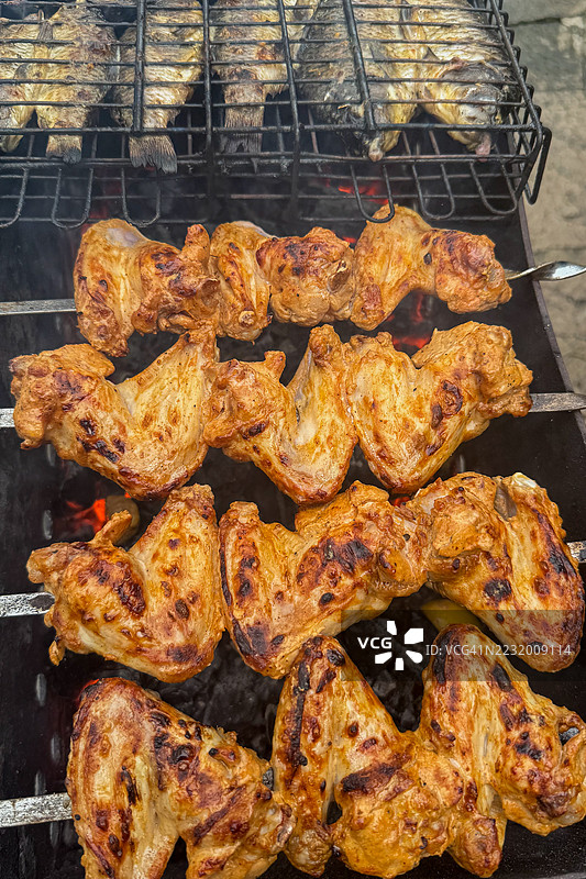 烧烤架上的烤鸡翅和鱼图片素材