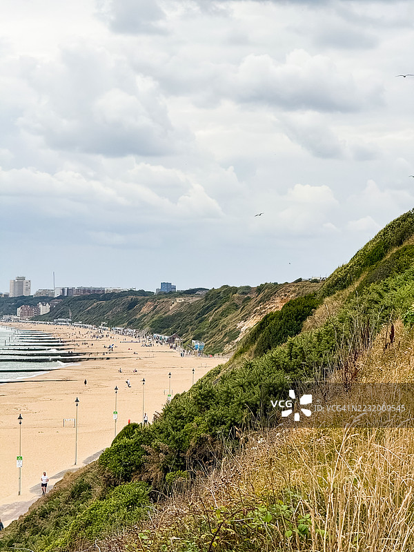 布莱克摩尔的繁忙海滩美景，悬崖和多云的天空，英国，博恩茅斯图片素材