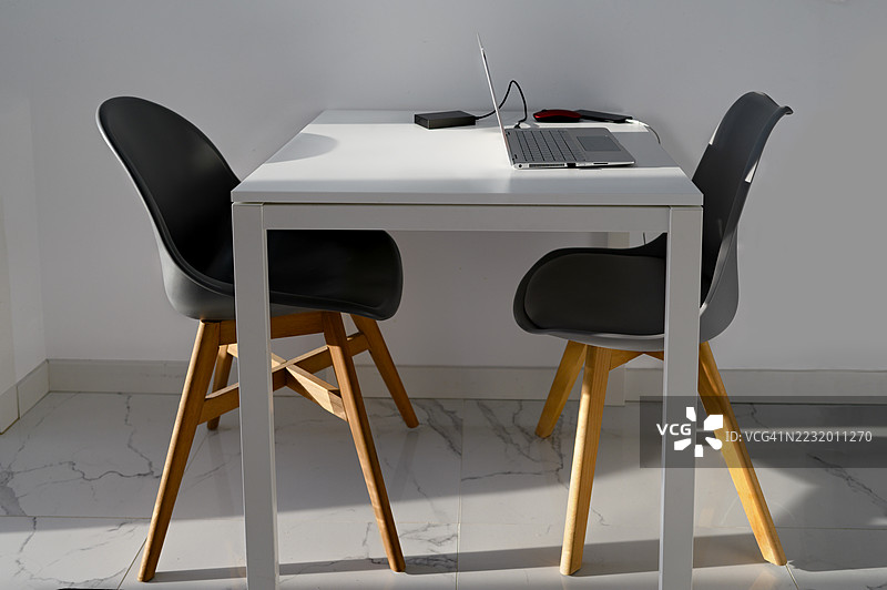 现代办公室布置，桌上有笔记本电脑和椅子图片素材
