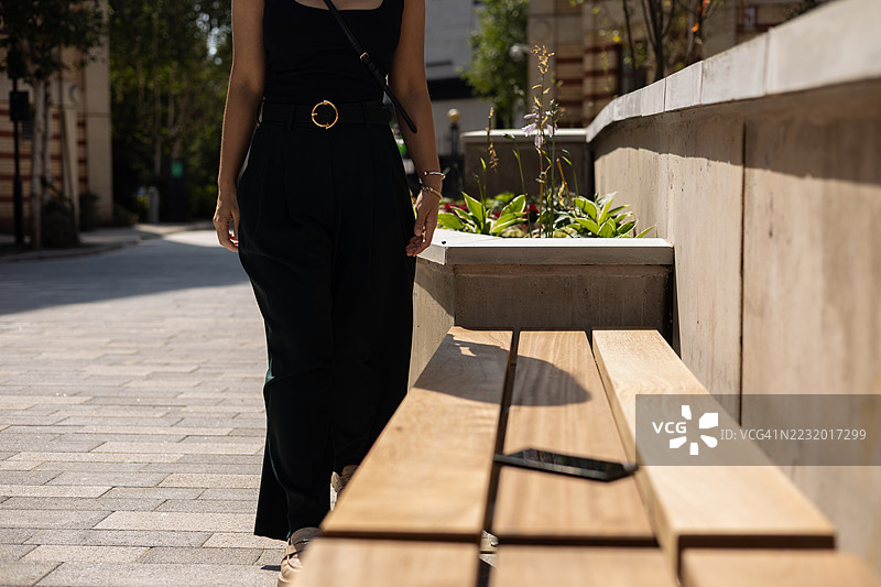 一位年轻女商人走在英国欧洲布里斯托市中心时，不小心掉落了她的智能手机图片素材