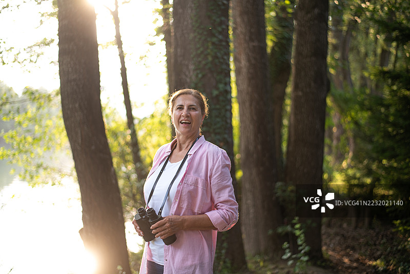 成熟的女性享受大自然，使用望远镜观察景物图片素材