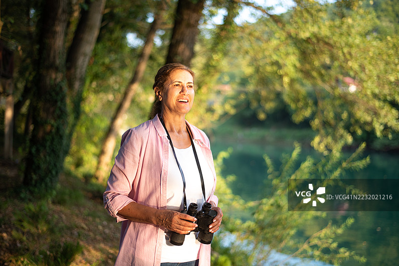 女性在自然环境中用望远镜探索图片素材