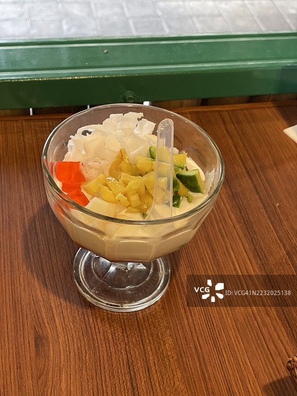 色彩缤纷的水果椰子甜点碗放在木桌上图片素材