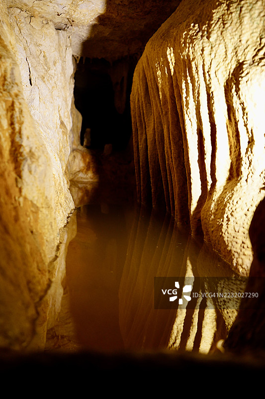 照亮的洞穴通道与水中的倒影图片素材