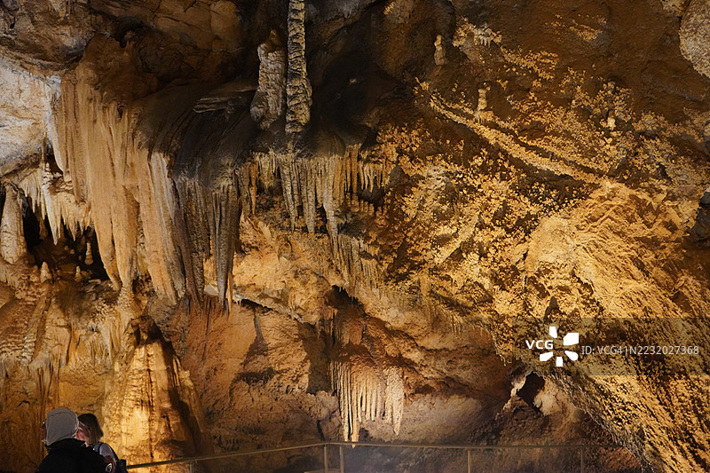 游客在探索有钟乳石和石笋的洞穴图片素材