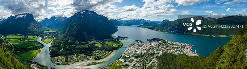 挪威劳马的峡湾全景，四周被山脉环绕，镇子在阴云密布的天空下。图片素材