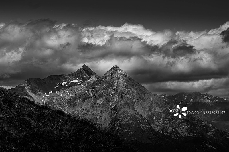 戏剧性的黑白雪山在多云天空下的景观图片素材