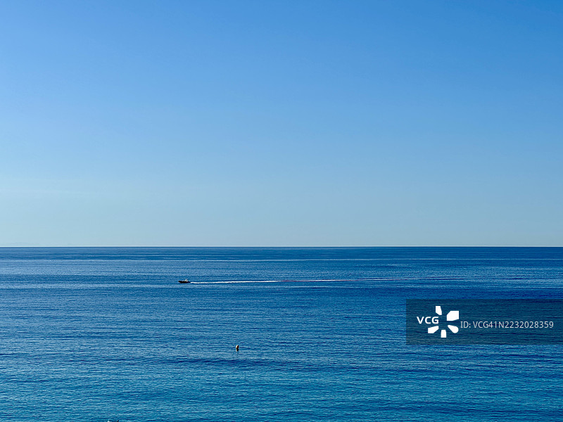 宁静的海洋景观在晴朗的蓝天下，法国门顿图片素材