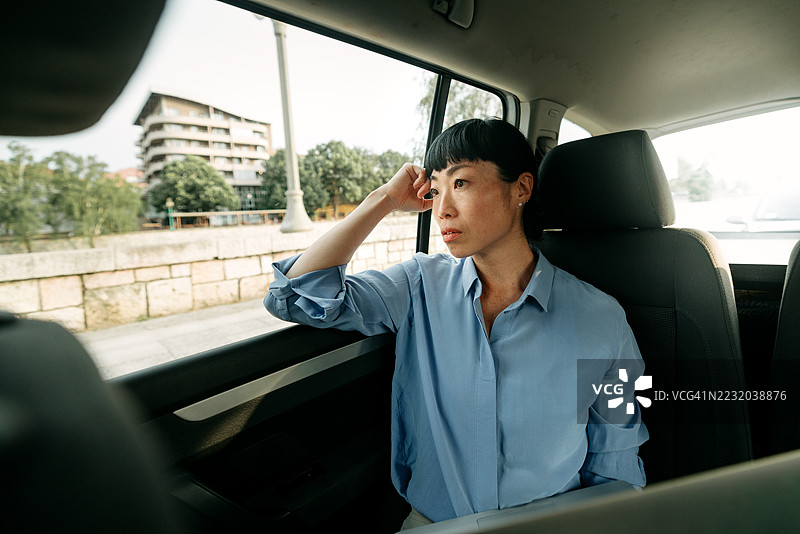 过度劳累的女商人在汽车后座上乘坐图片素材