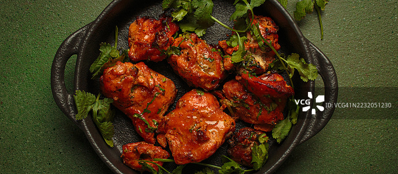 铸铁锅中的香菜烤鸡腿图片素材
