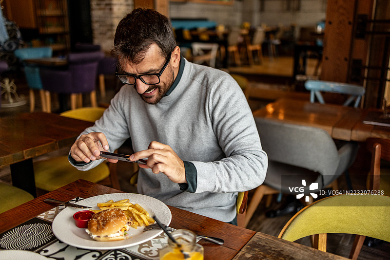快乐的顾客在餐厅拍摄食物照片图片素材