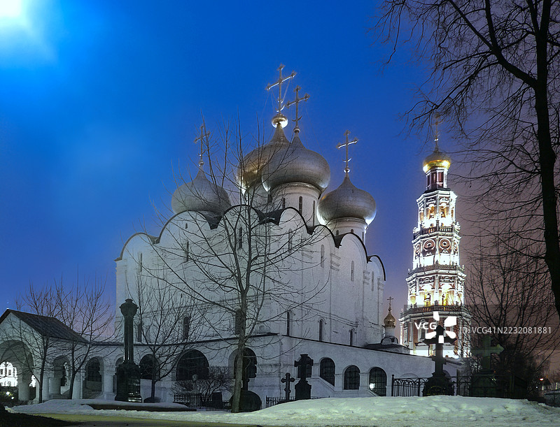 夜间或黄昏时分,莫斯科市中心的“新圣女修道院”(又名“斯摩棱斯克圣母大教堂”)特写,周围覆盖着雪和月光。图片素材