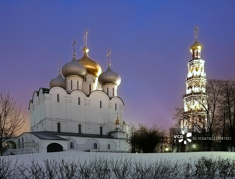 莫斯科市中心的“新圣女修道院”（又名“斯摩棱斯克圣母大教堂”）在黄昏晚些时候几乎入夜时分被雪覆盖，灯光照亮的特写图像。图片素材
