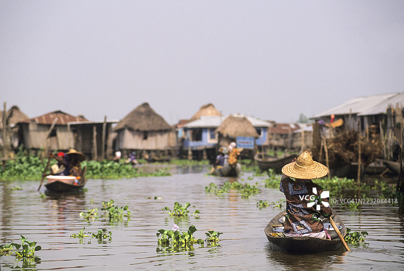 村民们在贝宁科托努附近的诺库湖甘维村乘坐独木舟移动图片素材