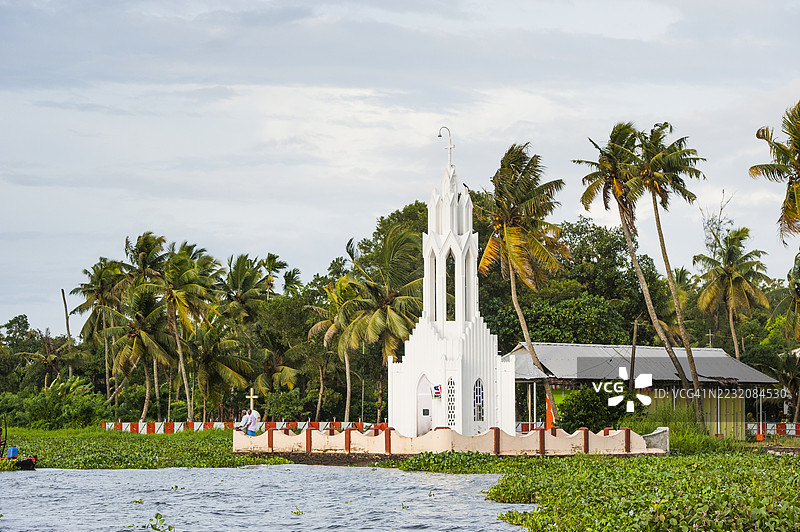 教堂被水葫芦包围，位于印度南部喀拉拉邦库马拉孔的回水运河中图片素材