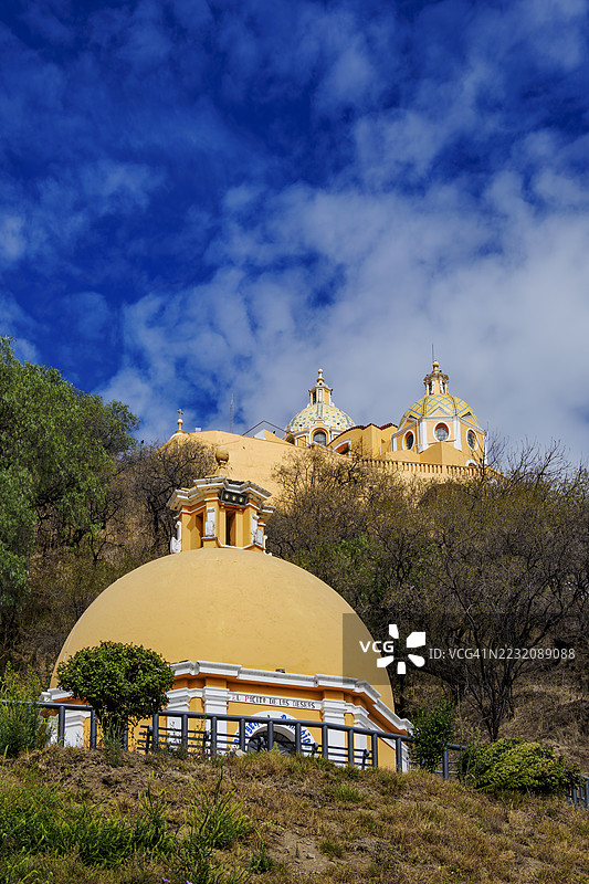 药物之井和位于墨西哥普埃布拉州乔卢拉大金字塔顶部的我们的圣母教堂图片素材