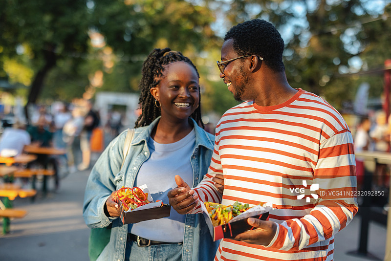 快乐的朋友们在热闹的社区聚会上享受户外街头美食图片素材