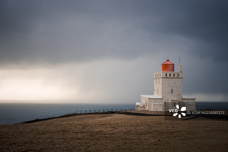 冰岛南部海岸的迪尔霍拉伊灯塔在暴风雨中的景象，极地地区图片素材