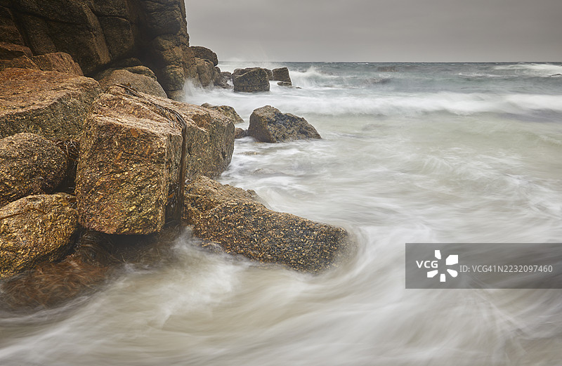 大西洋的海浪拍打着位于英国康沃尔西部兰兹角附近的波斯夸拉湾的花岗岩海岸岩石。图片素材