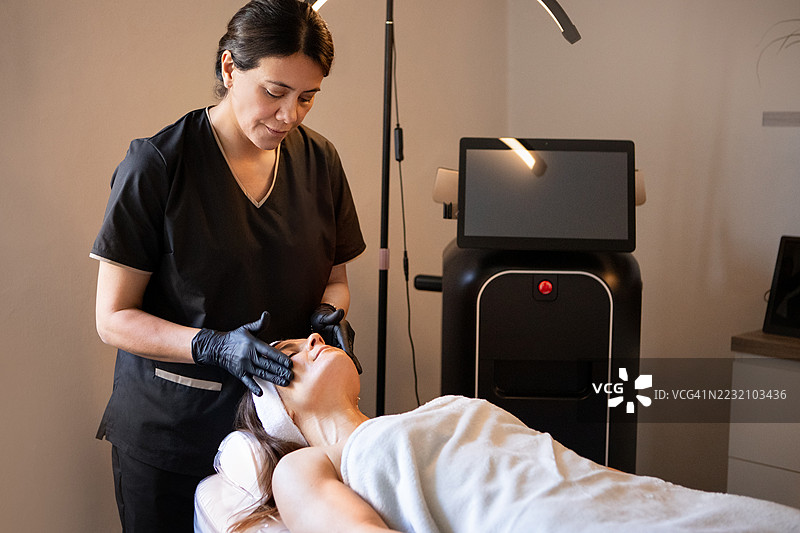 皮肤科医生在给患者进行面部按摩，注射了肉毒杆菌后。图片素材