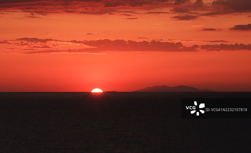 落日余晖映照地平线，前景是地中海。图片素材