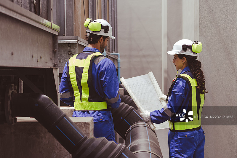 工程师正在检查大型工业建筑的水冷却塔空调，这是用于控制空气系统的水冷却塔空气冷却器HVAC。图片素材