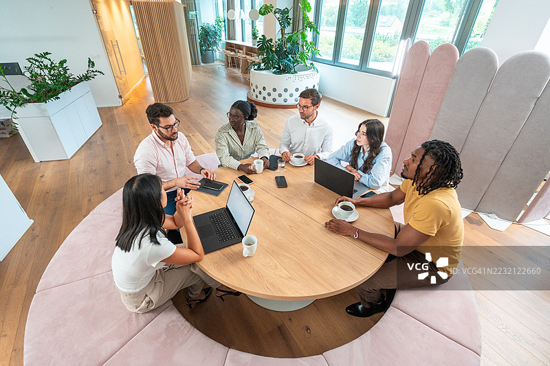 多元化的商业高管在现代节能办公室内合作，办公室内有自然光照射图片素材