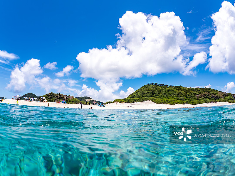 美丽的小斑点飞鱼，Trachinotus baillonii，栖息在美丽的白色沙滩上。半水面摄影。一群热带鱼。美丽的珊瑚礁和游泳的人们。Gahi岛，座间味岛，慶良間群岛，岛尻郡，冲绳 - 2025图片素材