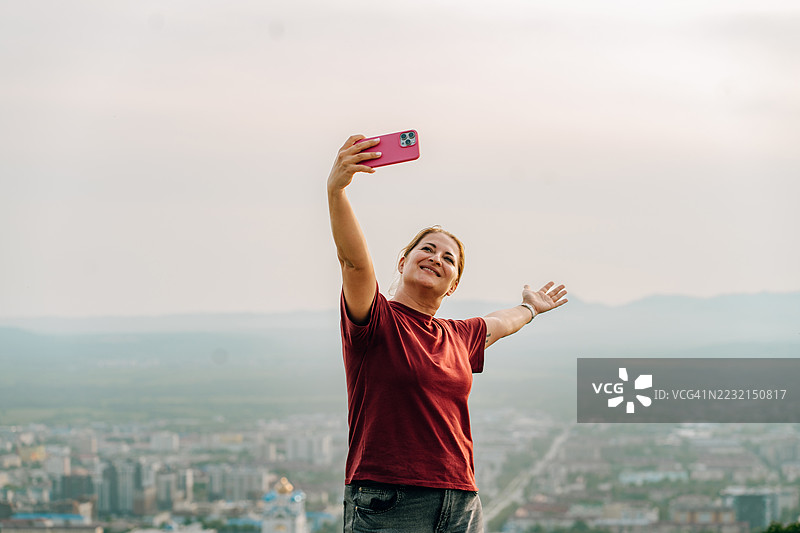 游客在萨哈林地区享受全景城市景观时自拍图片素材