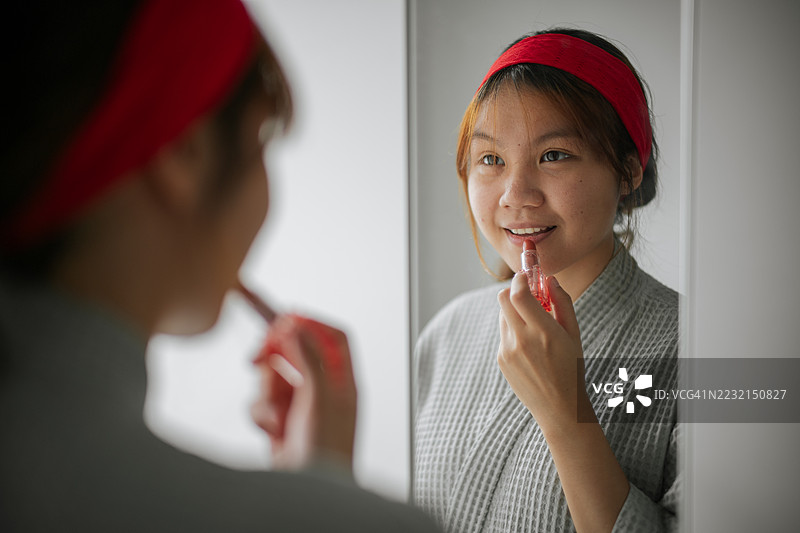 在镜子和衣柜前涂抹口红。图片素材