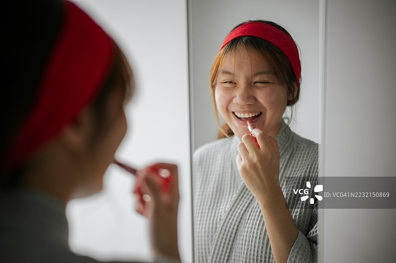 在镜子衣橱前涂抹口红图片素材