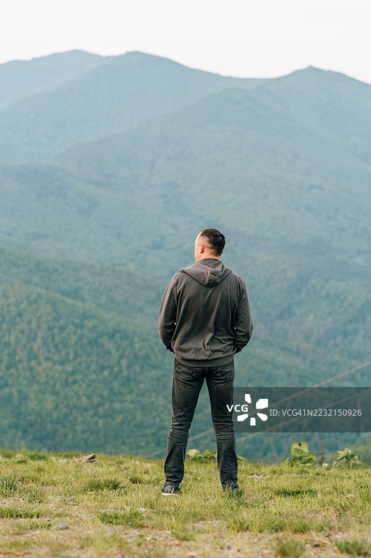 夏季在萨哈林地区，徒步旅行者欣赏鼓舞人心的山景图片素材