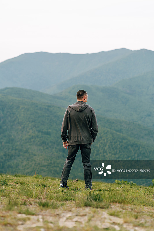 徒步旅行者在鼓舞人心的风景中沉思壮丽的山景图片素材