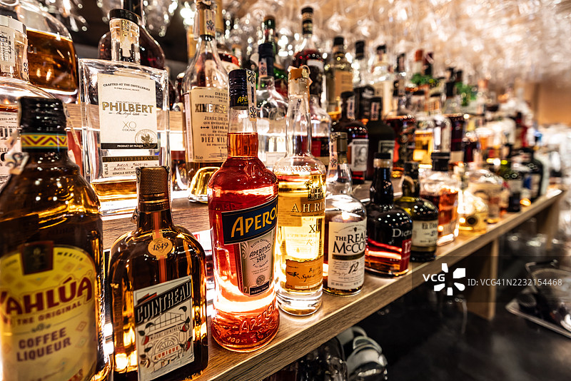 餐厅酒吧里的威士忌、朗姆酒和其他烈酒瓶。各种酒类标签、品牌和调制鸡尾酒及饮品的材料。图片素材