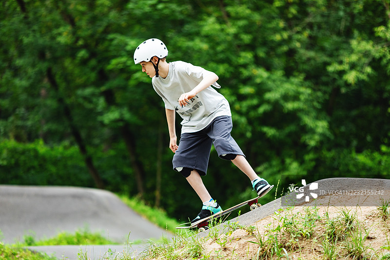 学龄男孩在泵道上滑板图片素材