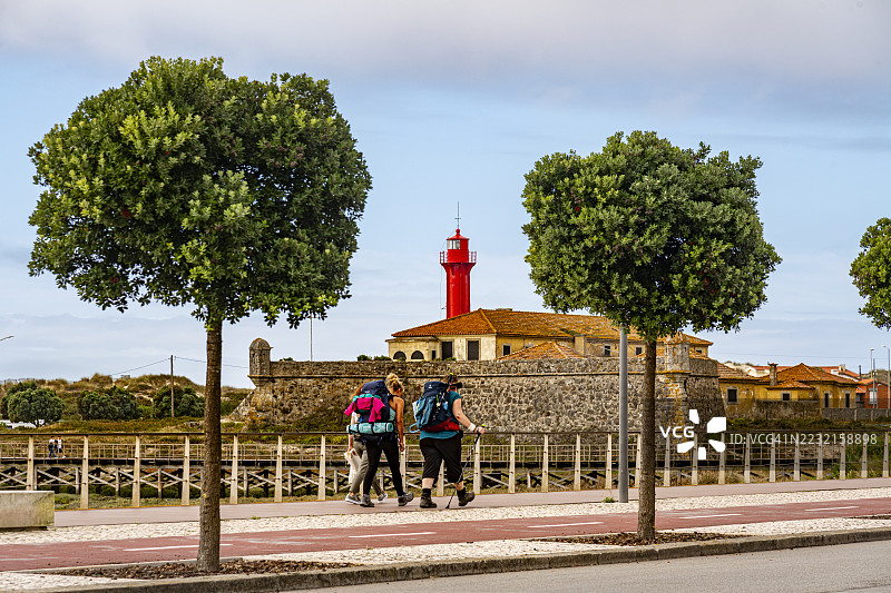 葡萄牙埃斯波赞德，背包客在海滩旁的人行道上图片素材