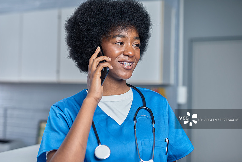 穿着医务工作服的快乐医疗专业人士在办公室使用智能手机图片素材