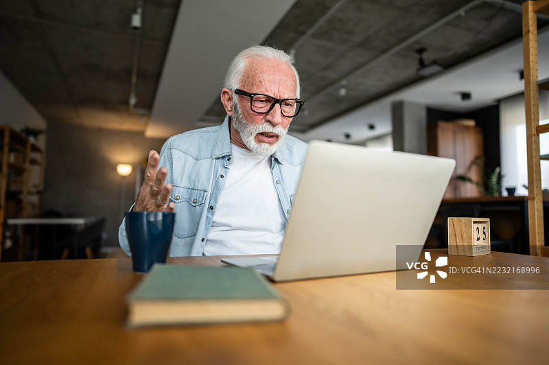 感到沮丧的老年男子在使用笔记本电脑时遇到问题图片素材