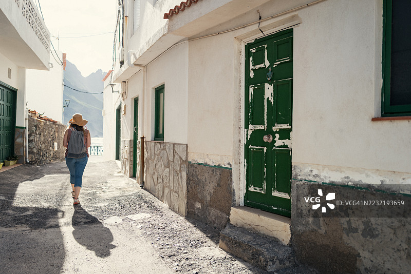 女人在特内里费海滨村庄狭窄的街道上行走图片素材