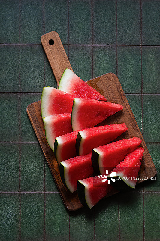 一颗成熟的新鲜绿色西瓜在绿色背景上。夏季水果和浆果的季节。图片素材