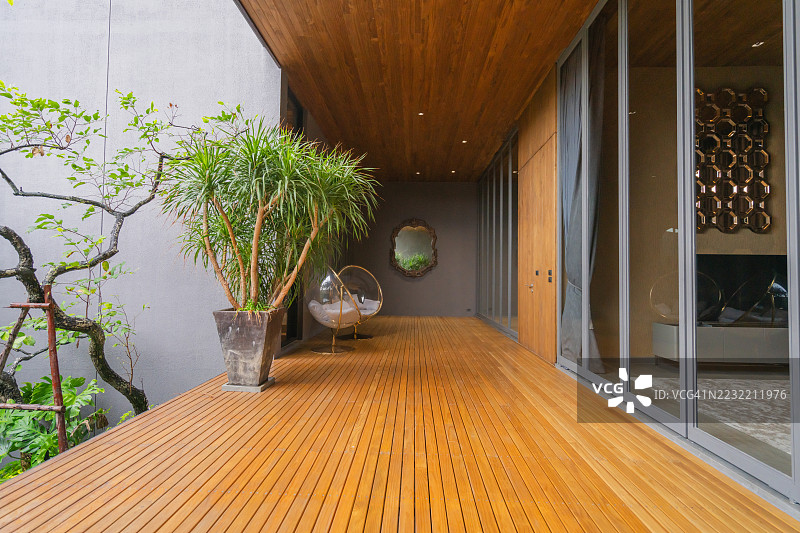 美丽的家居室内设计概念，现代房屋设计配有木质露台，户外自然光照。图片素材
