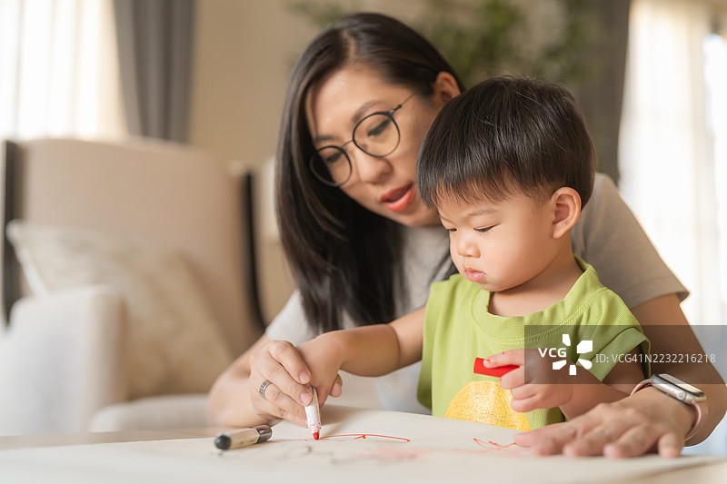 亚洲幼儿男孩与保姆在家一起绘画涂鸦图片素材