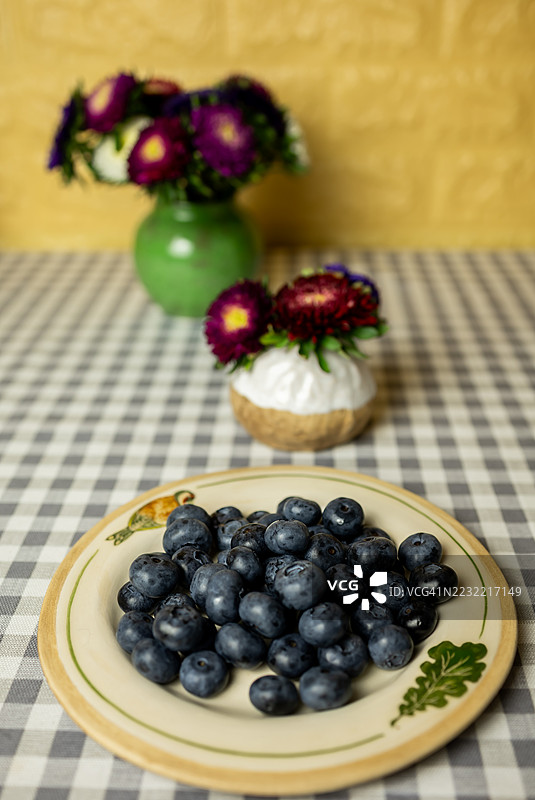 一盘新鲜蓝莓放在格子桌布上图片素材