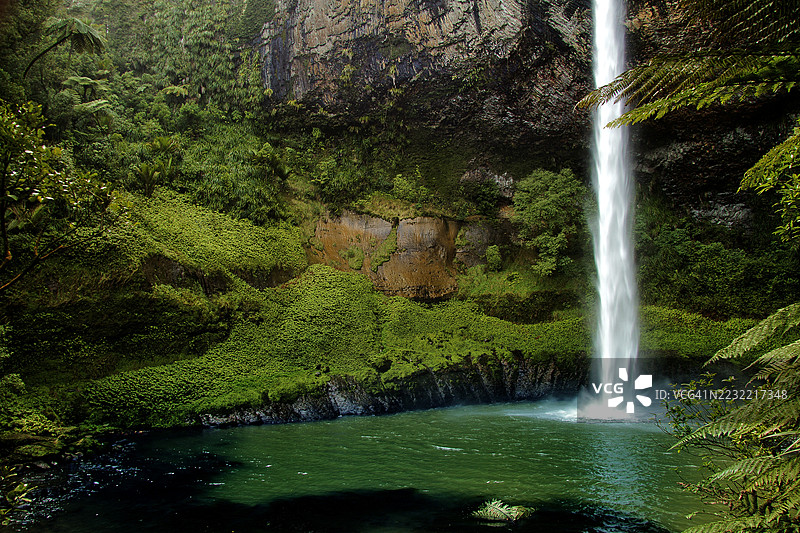 壮观的瀑布倾泻入郁郁葱葱的森林池塘图片素材