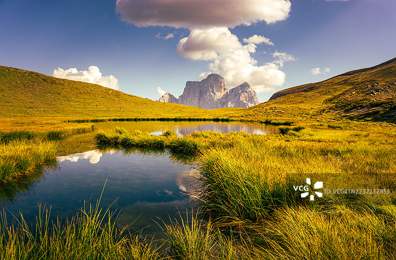 宁静的山湖映照着阳光明媚的风景中的云彩，意大利卡多雷森林。图片素材