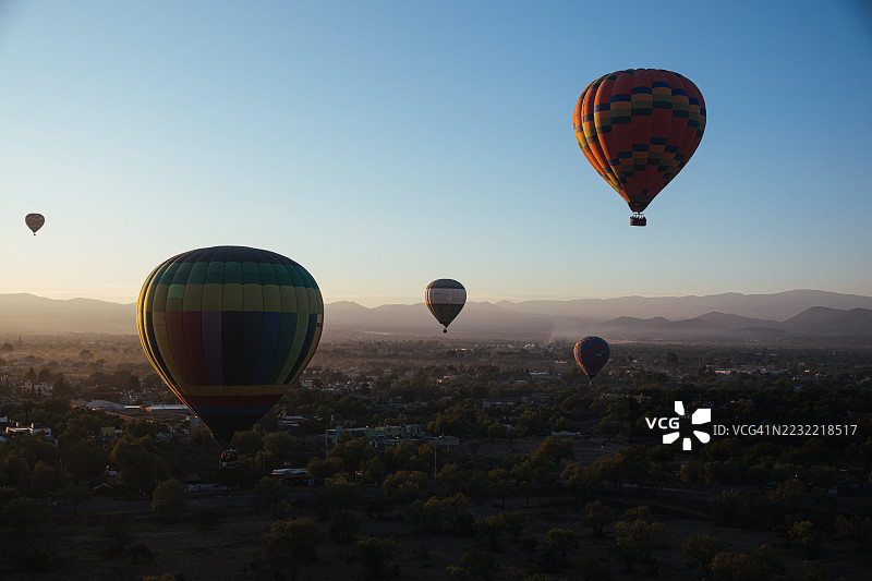 日出时分热气球飘浮在墨西哥风景优美的地貌上空图片素材