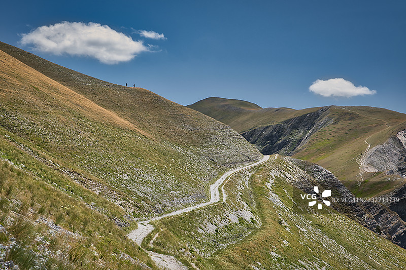 蓝天下，蜿蜒的山路穿过起伏的丘陵，通往意大利的卡斯泰尔桑坦杰洛苏尔内拉。图片素材